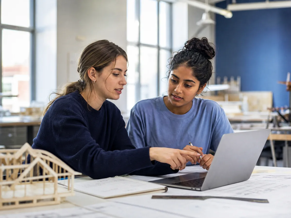 Two women reviewing an architecture project on a laptop